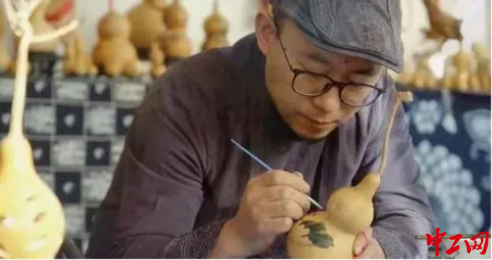 亢剛在葫蘆上作畫。